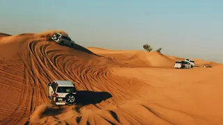 سيارات دفع رباعي تسير فوق كثبان الصحراء