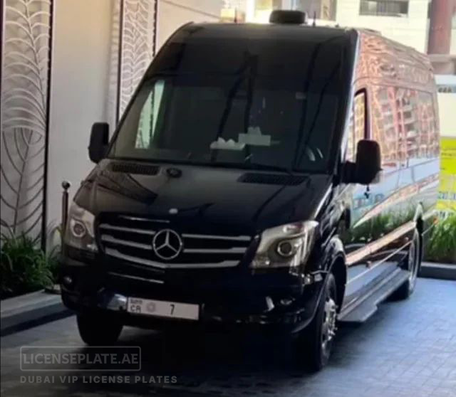 Black Mercedes Sprinter van with Dubai license plate CR 7 parked at a hotel entrance.