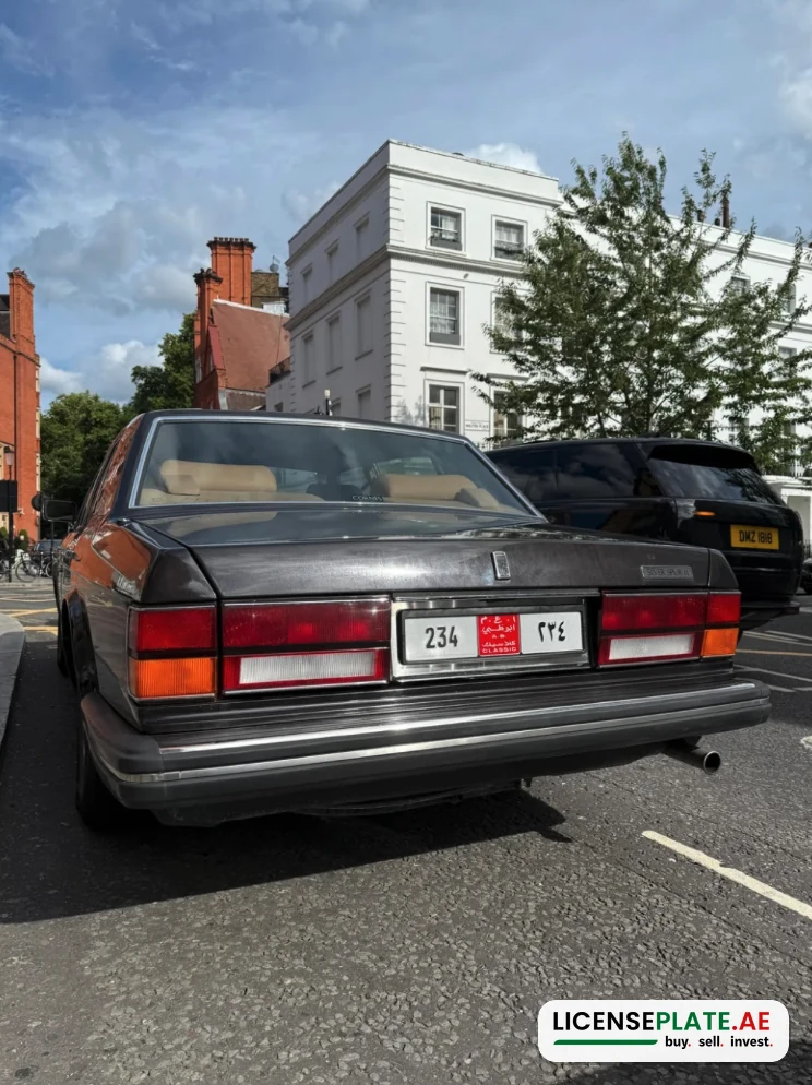Rear view of the Rolls-Royce Silver Spur II on Abu Dhabi Classic plate 234 parked on Walton Place, with a Range Rover on a British yellow plate behind it.
